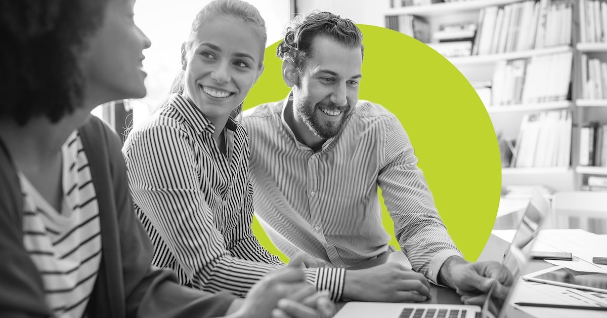 Working together on project. Happy young business colleagues working in office