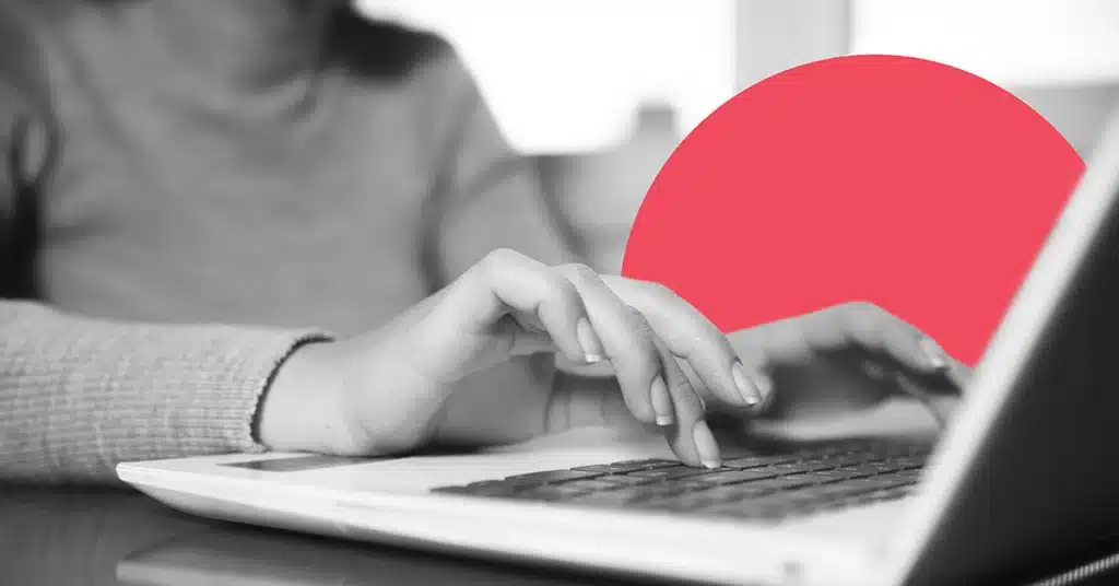 Closeup of a woman typing on a laptop keyboard.